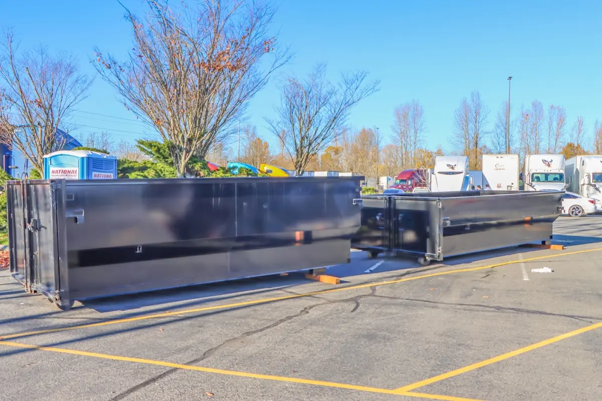 Professional dumpster rental service with roll-off container on residential driveway in Milford